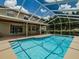 Backyard view of a screened-in pool, lush landscaping and a covered patio, perfect for outdoor entertaining at 5315 Cedarshake Ln, Valrico, FL 33596