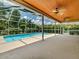 View of a screened-in pool area featuring a wood plank ceiling, ceiling fans and views of the pool and backyard at 5315 Cedarshake Ln, Valrico, FL 33596