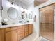 Bright bathroom featuring double sinks, attractive fixtures, and tiled shower at 5663 Sunset Falls Dr, Apollo Beach, FL 33572