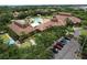 Aerial view of a beautiful clubhouse and pool area with palm trees and a parking lot at 5663 Sunset Falls Dr, Apollo Beach, FL 33572