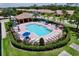 Aerial view of community pool featuring lounge chairs, umbrellas, and lush landscaping at 5663 Sunset Falls Dr, Apollo Beach, FL 33572