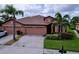 Well-manicured lawn and landscaping accent this lovely home with a terracotta roof and two-car garage at 5663 Sunset Falls Dr, Apollo Beach, FL 33572