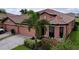 Charming single-story home featuring a terracotta roof, mature landscaping and a two car garage at 5663 Sunset Falls Dr, Apollo Beach, FL 33572