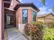 Close up of home's front entrance featuring a decorative glass door and colorful landscaping at 5663 Sunset Falls Dr, Apollo Beach, FL 33572