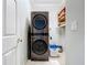 Efficient laundry room with stacked washer/dryer and shelving for storage at 5663 Sunset Falls Dr, Apollo Beach, FL 33572