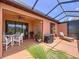 Relaxing covered patio area with a ceiling fan, dining table, grill, and comfortable lounge chair at 5663 Sunset Falls Dr, Apollo Beach, FL 33572