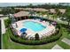 Aerial view of a resort style pool, lounging chairs, umbrellas, and meticulously landscaped grounds at 5663 Sunset Falls Dr, Apollo Beach, FL 33572