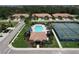 Aerial view of a community pool, cabana, tennis courts, and nearby residential properties at 5663 Sunset Falls Dr, Apollo Beach, FL 33572