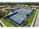 Overhead view of well-maintained community tennis and pickleball courts surrounded by manicured landscaping at 5663 Sunset Falls Dr, Apollo Beach, FL 33572
