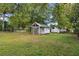 Exterior view of backyard with green lawn and storage shed at 5906 12Th St, Zephyrhills, FL 33542