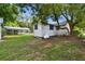 Exterior view of backyard with green lawn, shed, and carport at 5906 12Th St, Zephyrhills, FL 33542
