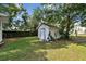 Exterior view of backyard with green lawn and storage shed at 5906 12Th St, Zephyrhills, FL 33542