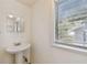 Bathroom with tiled floors, a pedestal sink, a mirror, and a window with natural light at 5906 12Th St, Zephyrhills, FL 33542