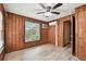 Bedroom with wood-paneled walls, tiled floors, a ceiling fan, and a window air conditioning unit at 5906 12Th St, Zephyrhills, FL 33542