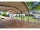 View of metal carport over leaf covered parking spot at 5906 12Th St, Zephyrhills, FL 33542