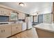Bright kitchen with white appliances, laminate countertops, and wood-look flooring at 5906 12Th St, Zephyrhills, FL 33542