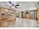 Open layout connecting the kitchen and living room with ceiling fans and wood-look floors at 5906 12Th St, Zephyrhills, FL 33542