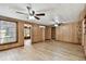 Spacious living room with wood-look flooring, ceiling fans, and ample natural light at 5906 12Th St, Zephyrhills, FL 33542