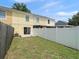 View of the partially fenced backyard with sliding glass doors leading into the home at 6114 Oak Cluster Cir, Tampa, FL 33634