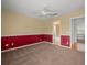 Bedroom featuring carpet, paneled walls, ceiling fan and access to a bathroom at 6114 Oak Cluster Cir, Tampa, FL 33634