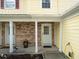 Inviting front porch with brick accents and white support columns and a nice flower bed at 6114 Oak Cluster Cir, Tampa, FL 33634