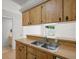 Bright kitchen featuring wood cabinets and a stainless steel double sink overlooking the backyard at 6114 Oak Cluster Cir, Tampa, FL 33634