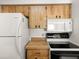 Functional kitchen featuring wood cabinets, a white refrigerator, and a microwave above the range at 6114 Oak Cluster Cir, Tampa, FL 33634