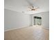 Large, airy living room features neutral tile flooring, ceiling fan, and sliding doors with backyard views at 6114 Oak Cluster Cir, Tampa, FL 33634