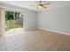 Open living area with neutral tile flooring, a ceiling fan, and sliding glass doors to the backyard at 6114 Oak Cluster Cir, Tampa, FL 33634
