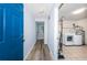 Hallway featuring wood floors, a blue door, and a laundry area with appliances at 6206 92Nd N Pl # 3605, Pinellas Park, FL 33782
