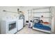 Well-equipped laundry room with washer, dryer, utility sink, and metal shelving for storage at 6206 92Nd N Pl # 3605, Pinellas Park, FL 33782