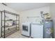 Laundry room featuring washer, dryer, hot water heater, and metal shelving for storage at 6206 92Nd N Pl # 3605, Pinellas Park, FL 33782