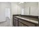 Bright bathroom featuring a dark vanity, ample counter space, and two doorways leading to other rooms at 7024 Bradbury Cir, Wesley Chapel, FL 33545