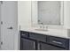 Modern bathroom vanity features dark cabinets and a white countertop, with a large mirror and modern fixtures at 7024 Bradbury Cir, Wesley Chapel, FL 33545