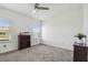 Bright bedroom with a ceiling fan, carpeted floor, and plenty of natural light from the windows at 7024 Bradbury Cir, Wesley Chapel, FL 33545