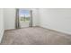 Bright bedroom with large window and curtains provides ample natural light, complimented by neutral-colored walls and carpet at 7024 Bradbury Cir, Wesley Chapel, FL 33545