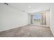 Bright bedroom features a large window with decorative drapes and neutral carpet at 7024 Bradbury Cir, Wesley Chapel, FL 33545