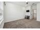 Bright bedroom with carpet floor includes a tv and console and a door that goes to another room at 7024 Bradbury Cir, Wesley Chapel, FL 33545