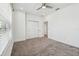 Light-filled bedroom with neutral walls, soft carpeting, a ceiling fan, closet and views of the outdoors at 7024 Bradbury Cir, Wesley Chapel, FL 33545