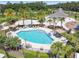 Stunning aerial view of a community pool surrounded by chairs and green spaces at 7024 Bradbury Cir, Wesley Chapel, FL 33545