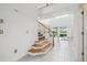 Bright entryway with staircase, high ceilings, and a view into the living area and backyard at 7024 Bradbury Cir, Wesley Chapel, FL 33545