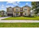 Inviting two-story home featuring a covered front porch and well-manicured lawn at 7024 Bradbury Cir, Wesley Chapel, FL 33545