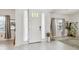 Bright foyer with tile flooring, decorative artwork and views of the front entrance at 7024 Bradbury Cir, Wesley Chapel, FL 33545