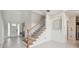 Bright foyer with staircase featuring wood railing and carpeted steps, and access to the main living area at 7024 Bradbury Cir, Wesley Chapel, FL 33545