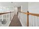 Upstairs hallway featuring wood and white railings and lots of light from the tall mirrors on one wall at 7024 Bradbury Cir, Wesley Chapel, FL 33545