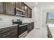Modern kitchen with dark wood cabinets and stainless steel appliances at 7024 Bradbury Cir, Wesley Chapel, FL 33545