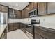 Modern kitchen with stainless steel appliances, dark wood cabinets, and light countertops at 7024 Bradbury Cir, Wesley Chapel, FL 33545