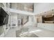 Bright open-plan living room with soaring ceilings, a modern staircase, and access to kitchen at 7024 Bradbury Cir, Wesley Chapel, FL 33545