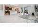 Open-concept living area with kitchen, large windows, and access to an outdoor seating area with a pool at 7024 Bradbury Cir, Wesley Chapel, FL 33545