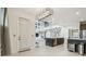 Bright, open-concept living room and kitchen boasts modern lighting, tiled floors, and stainless steel appliances at 7024 Bradbury Cir, Wesley Chapel, FL 33545